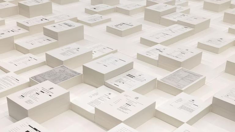 The stacks of government reports into Indigenous deaths in custody are part of an installation suspended above a pool of remembrance in Archie Moore’s kith and kin. Picture: Andrea Rossetti<br>